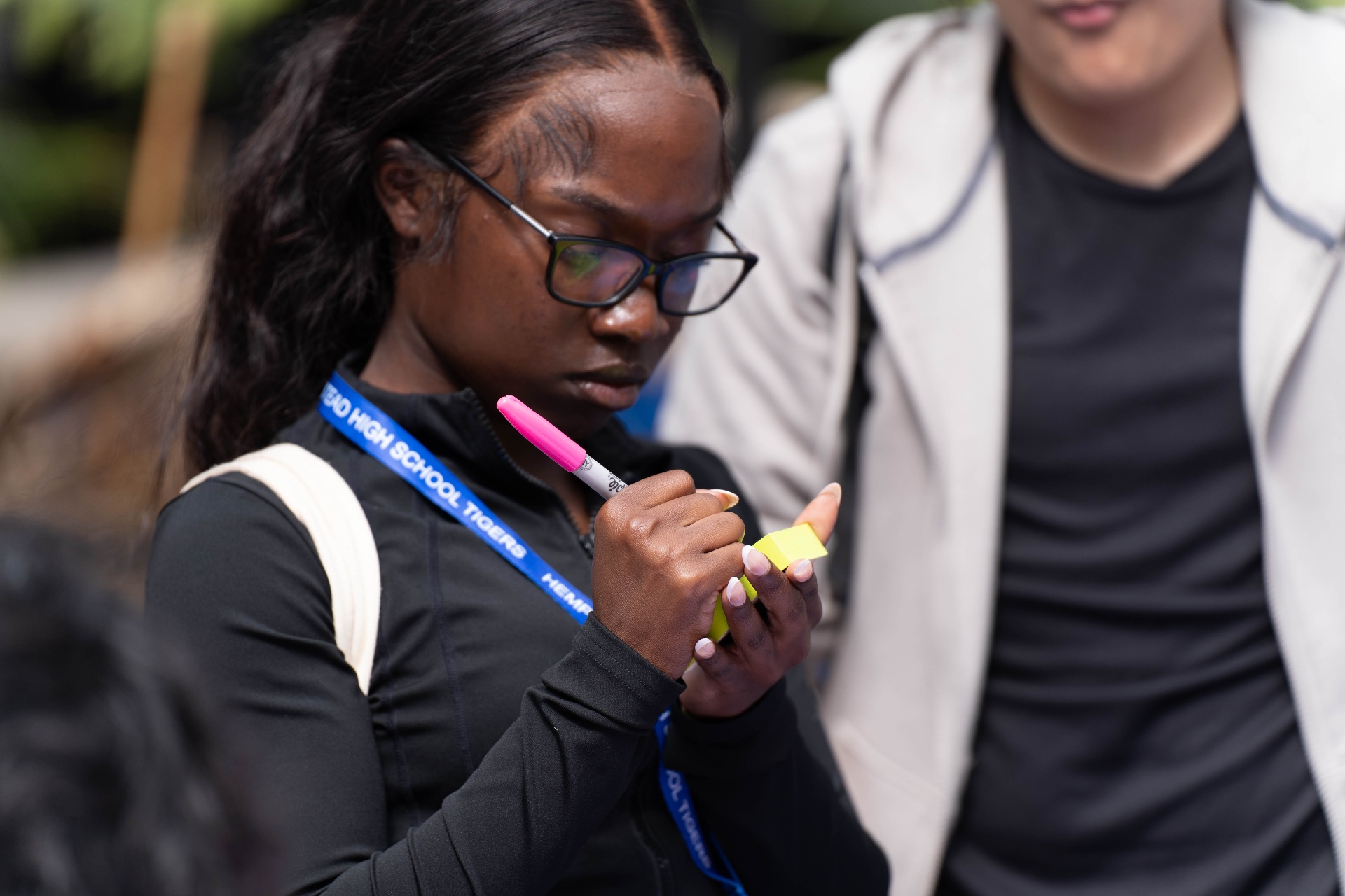 A Hempstead High School student writing a note for the Gratitude Wall