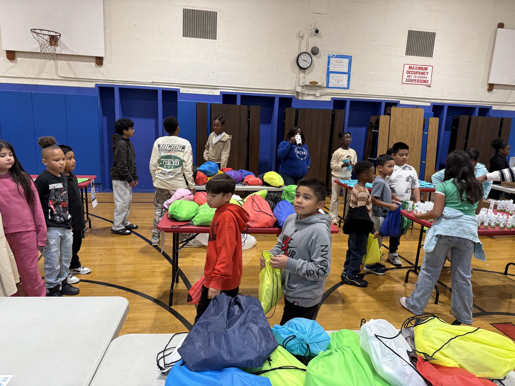Students filling colorful drawstring bags with essential items during the care package assembly at Joseph A. McNeil Elementary School