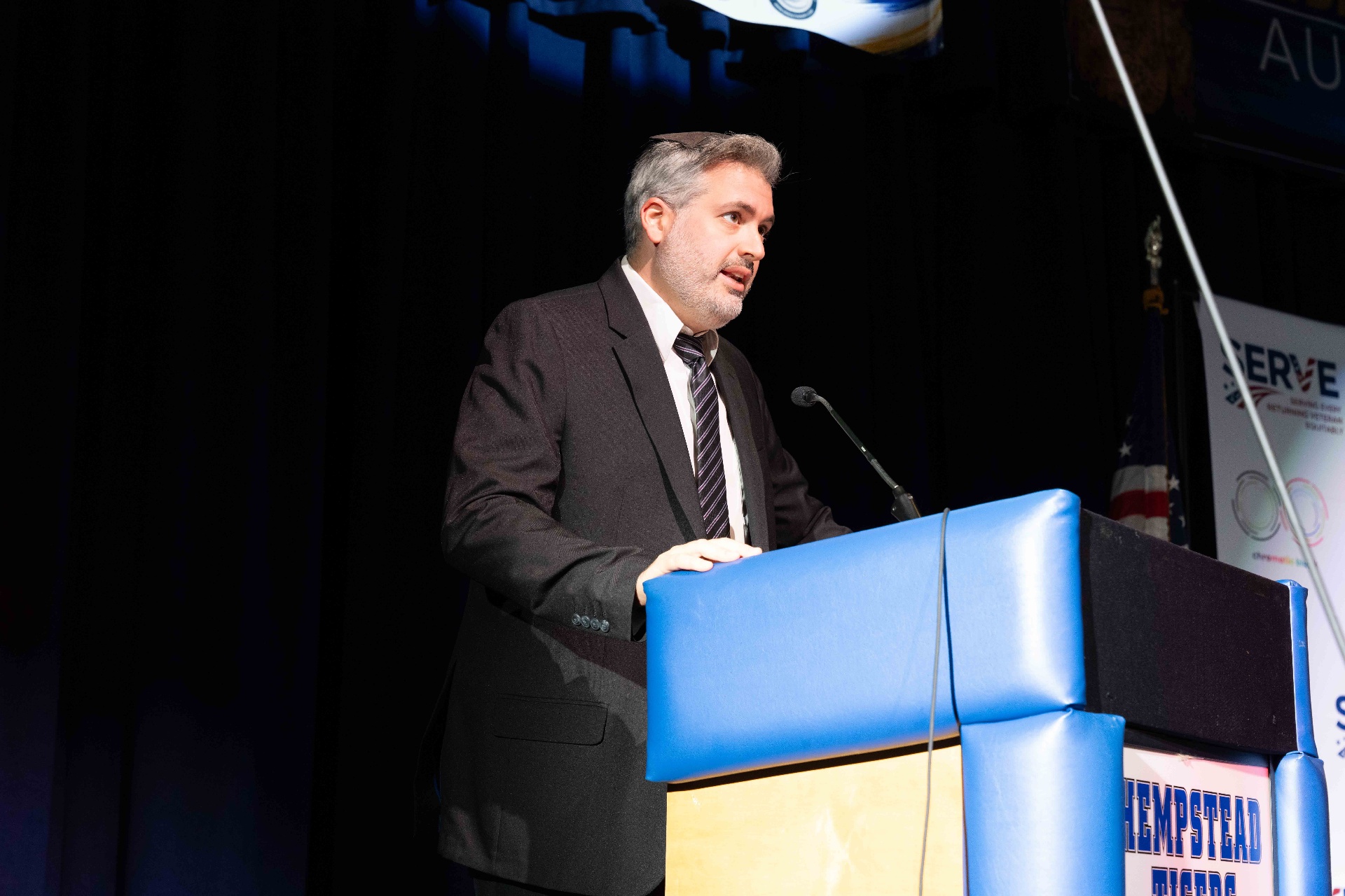 A speaker addressing students from the podium at the commemoration assembly